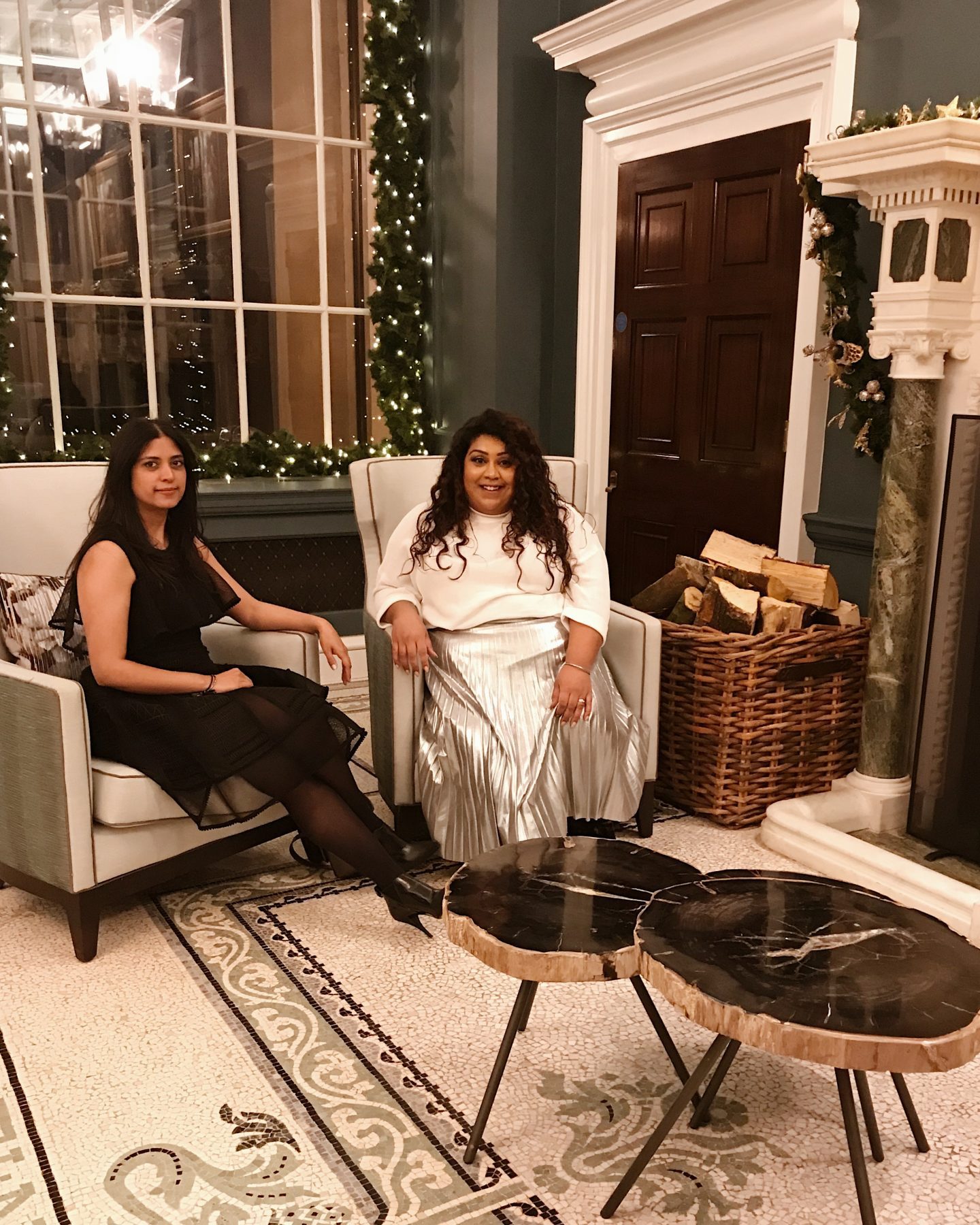 Afternoon Tea, Cocktails & A Tour Of The Langley Hotel Spa, Nishi V. Nishi and friend in chairs in front of a fire