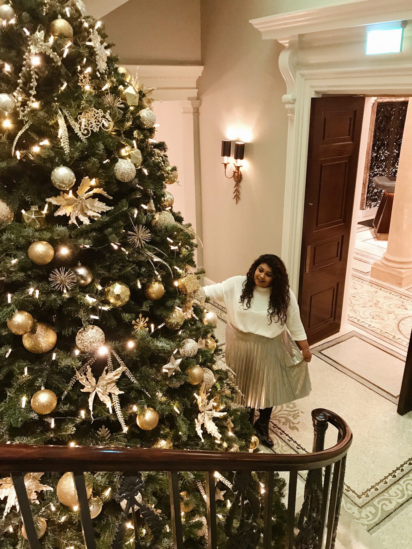 Afternoon Tea, Cocktails & A Tour Of The Langley Hotel Spa, Nishi V. Nishi at the bottom of stairs looking at a Christmas tree