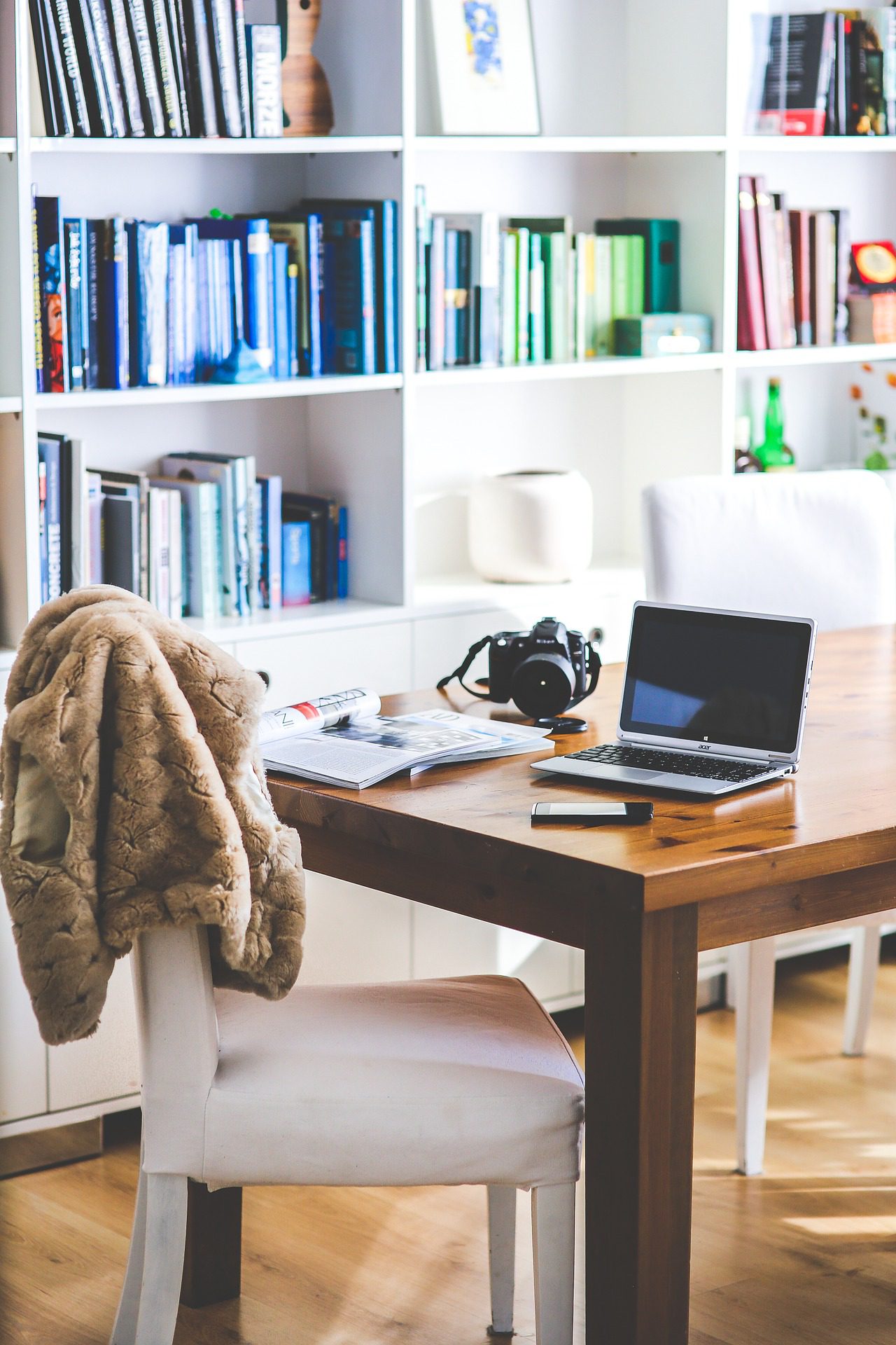 work space with laptop and camera on table.