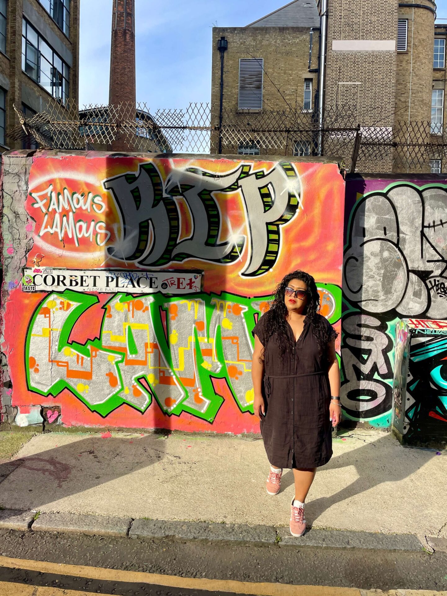 woman posing in front of shoreditch street art