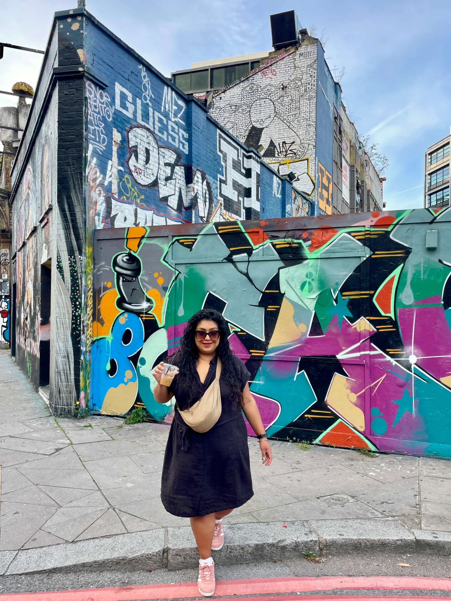 woman posing in front of shoreditch street art