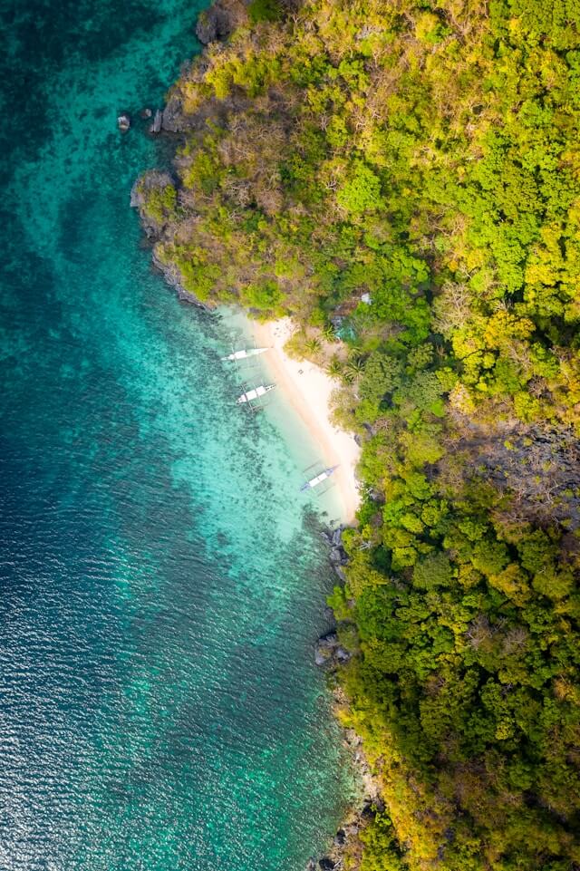 View of El Nido from above. The beautiful azure sea, white sandy beach and lush tropical forest in a contrast of colours