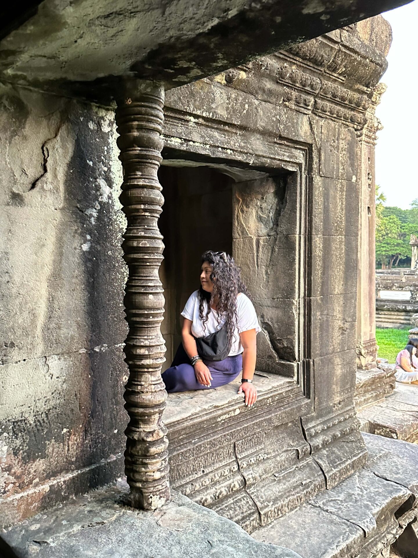 nishi sat on a window ledge at angkor wat