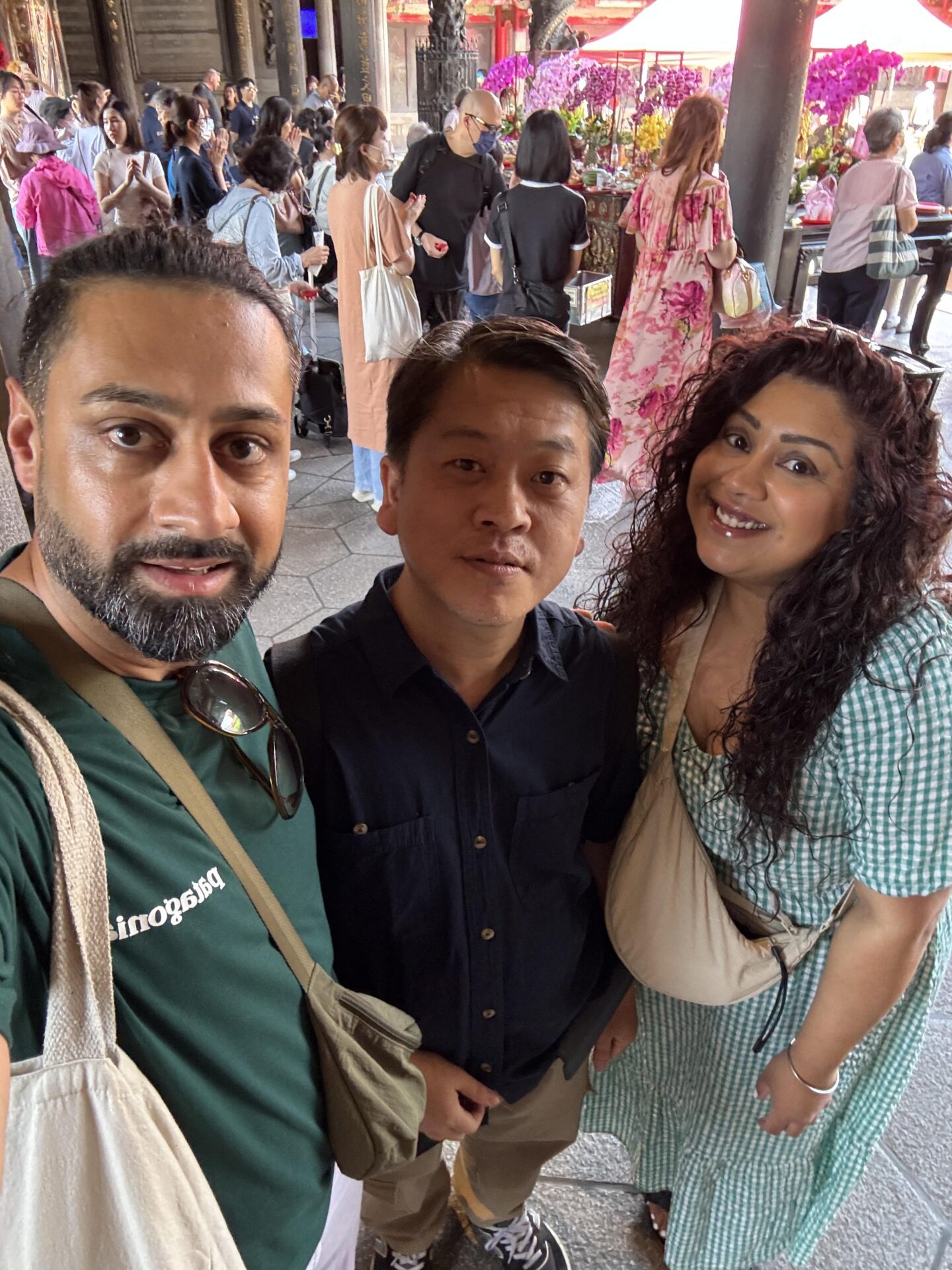 Nishi and Jass posing for a photo with a Taiwanese volunteer at Longshan Temple in Taipei