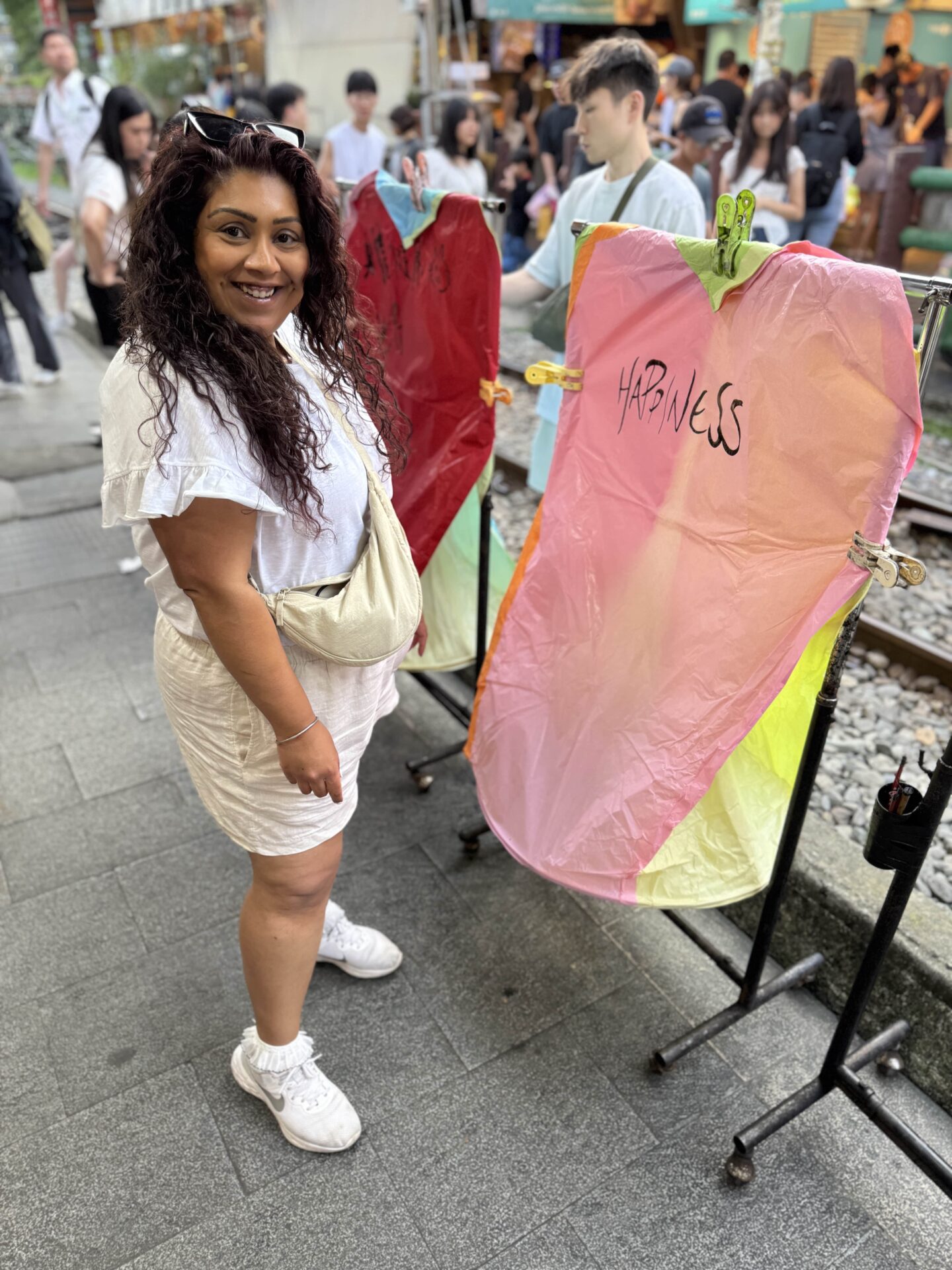 Nishi posing next to people setting off a colourful lantern in Shifen