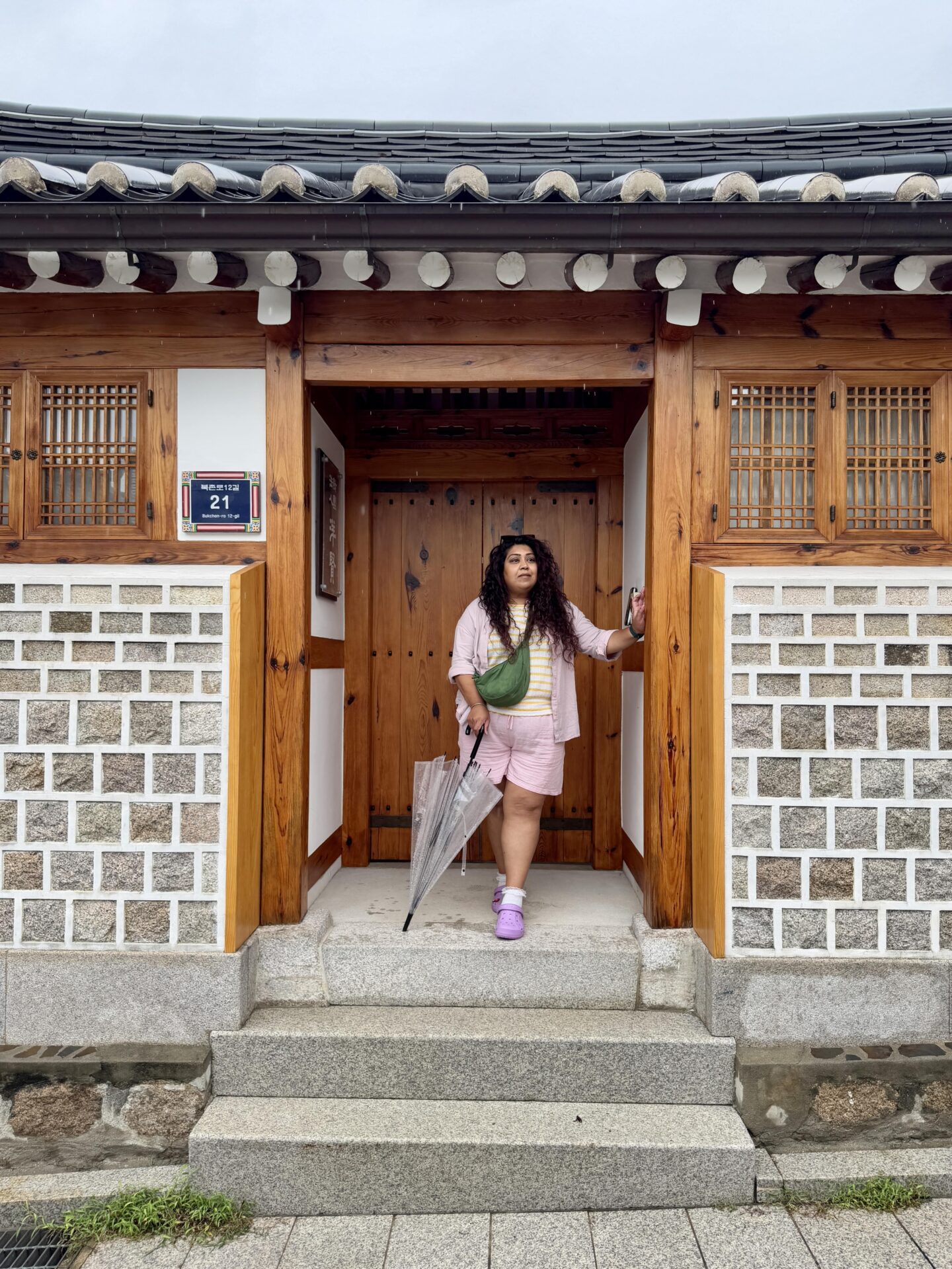 Nishi stood with an umbrella outside a house in Bukchon Hanok Village