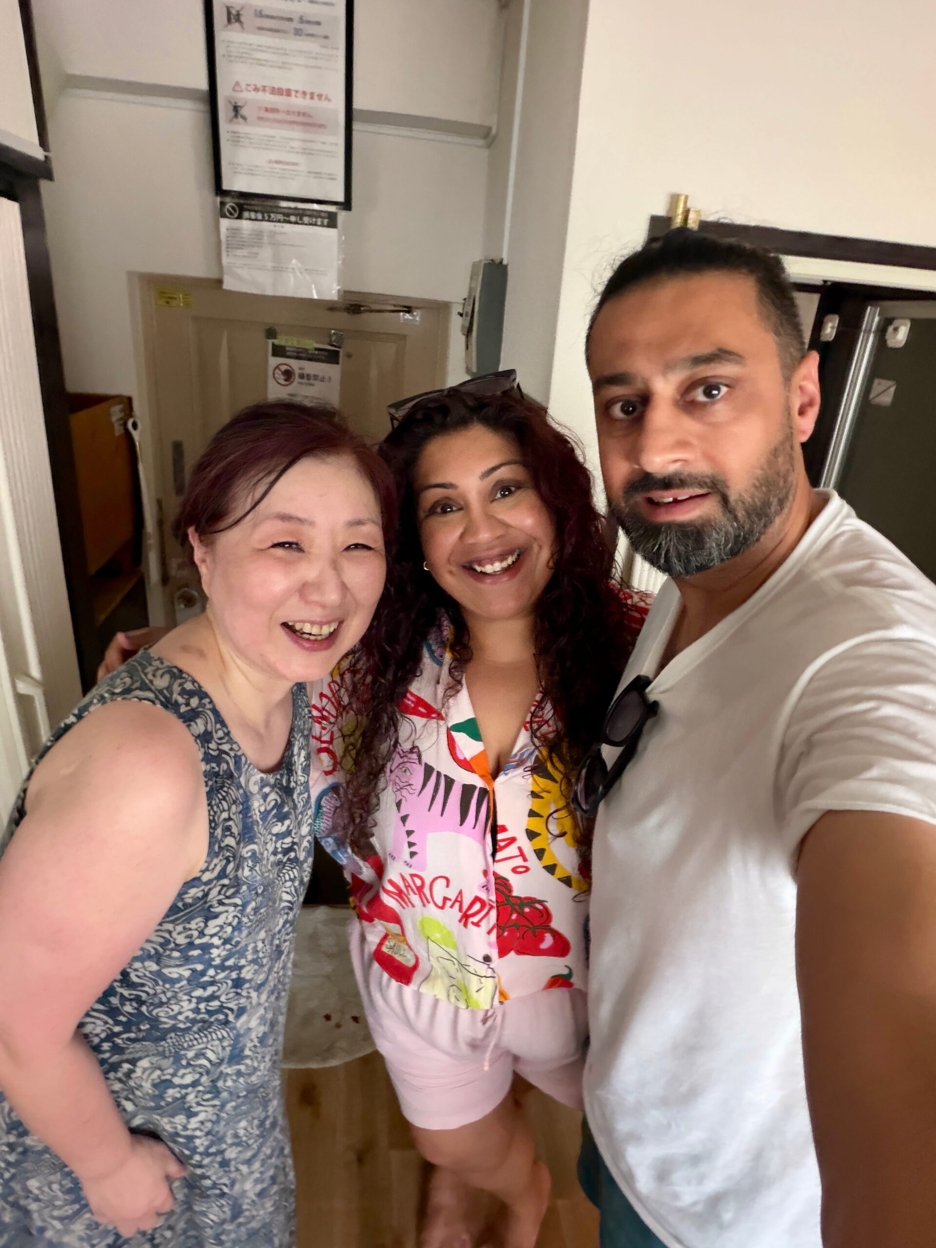 Nishi takes a smiling selfie with Megumi san and Jass during their rent a grandma experience in Tokyo. Nishi wears a colourful shirt while Megumi san wears a blue patterned dress and Jass wears a white T shirt.